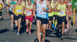 Sejumlah pelari marathon berlari bersama di jalan dengan memakai jersey bernomor dada.
