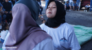 2 Orang Perempuan Dewasa Sedang Berlomba Estafet Karet dengan Sedotan